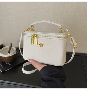 Close-up of a cream leopard print crossbody box bag with golden flower hardware