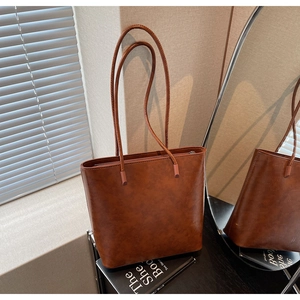 Detail of vintage brown leather tote bag with long shoulder straps and fine texture