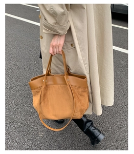 Detail showing the contrast between smooth brown leather and matte suede on tote bag