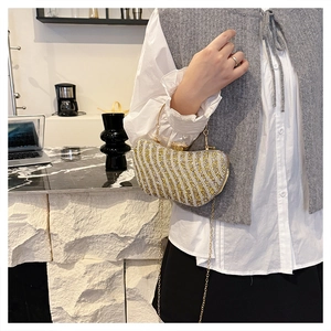 Dettaglio borsa da sera a mezzaluna con strass oro e argento e motivi a onde