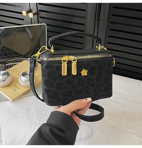 Close-up of leopard pattern mini box bag with golden floral hardware and dual zipper