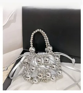 Detail of silver beaded handbag with hollow structure and silk drawstring inner pouch