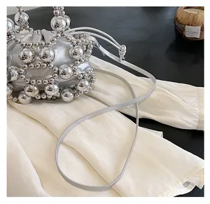 Detail of silver beaded bucket bag with mesh weave texture and smooth drawstring inner