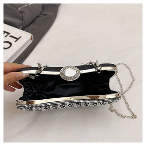 Dettaglio della pochette da sera con strass, fodera in raso nero e chiusura a scatto