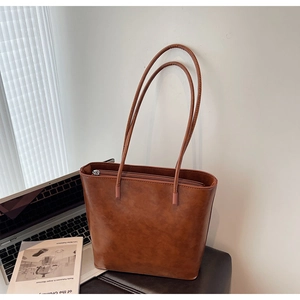 Brown vintage tote bag with PU texture and laptop in a minimalist home office setting