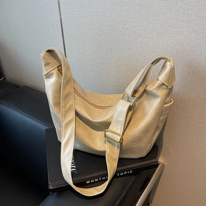 Minimalist beige dumpling shoulder bag with soft leather texture and golden metal buckle