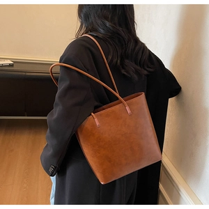 Brown vintage faux leather tote bag showing large capacity and long shoulder straps