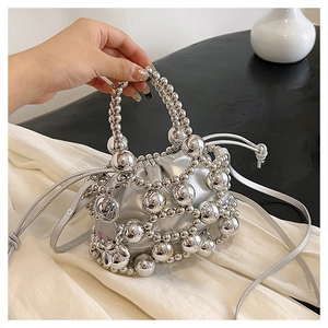 Detail of silver beaded handbag with mesh structure and metallic drawstring lining