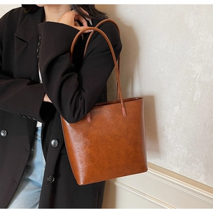 Macro detail of the vintage caramel brown tote bag showing smooth leather texture