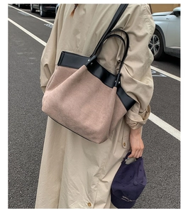 Outdoor lifestyle view of a large two-tone canvas tote bag with black leather straps