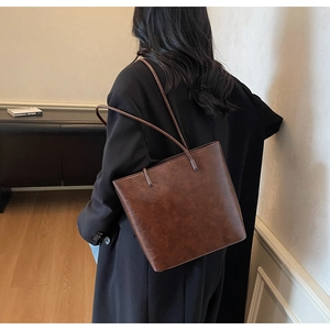 Macro view of vintage brown tote bag texture and long shoulder straps for women
