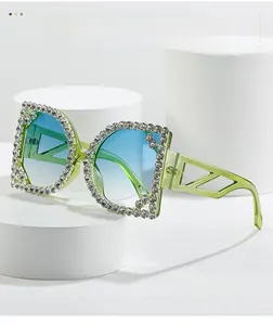 Detail of light green sunglasses with rhinestone-encrusted frames and blue gradient lenses