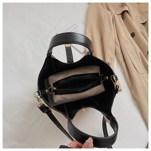 Top view of large black leather bucket bag with beige canvas inner pouch and gold lock