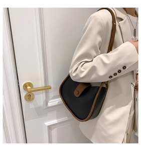 Detail of half-moon shoulder bag with black and brown contrast leather and buckle closure