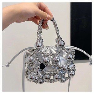 Detail of silver beaded handbag with metallic dog charm and drawstring interior pouch
