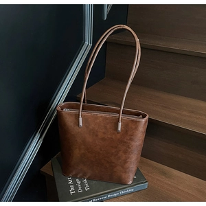 Close-up of vintage dark brown tote bag with distressed texture and metal zipper