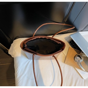 Macro detail of brown leather tote bag showing spacious interior and secure zipper closure