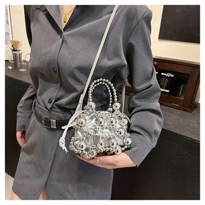 Detail of silver beaded mini handbag with large metallic pearls and leather crossbody strap