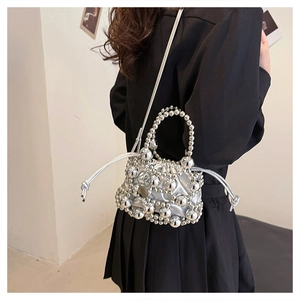 Detail of silver metallic beaded handbag with hollow pearl texture and shoulder strap