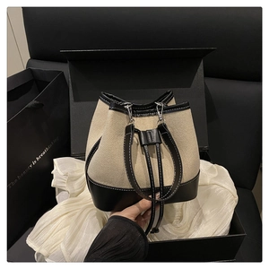 Canvas and leather bucket bag inside a premium black gift box with a shopping bag