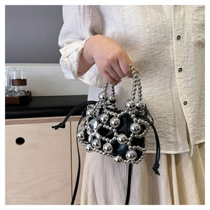 Close-up of woven silver bead framework with black drawstring pouch interior