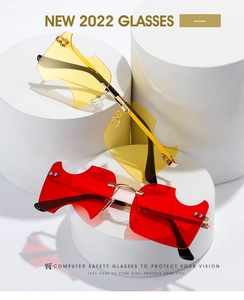 Détail de lunettes de soleil sans monture rouges et jaunes avec découpe géométrique et or