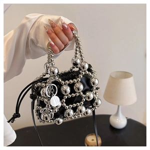 Detail of black drawstring crossbody bag with silver beaded mesh and pearl charm