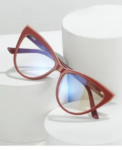 Detailed view of red tortoiseshell cat-eye glasses frame on white geometric podiums