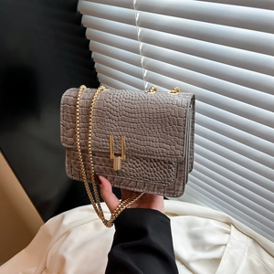 Grey croc-embossed crossbody chain bag with gold U-shaped lock and multi-layered design