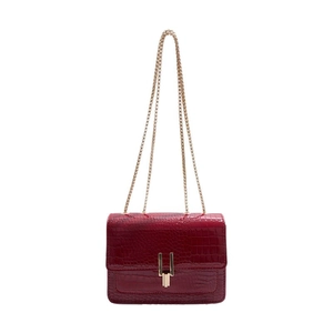 Red crocodile texture shoulder bag with gold chain strap on white background