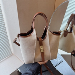 Beige canvas tote bag with brown leather trim and golden twist lock closure