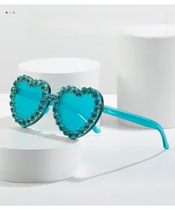 Détail de lunettes de soleil en forme de cœur avec verres bleus et strass scintillants