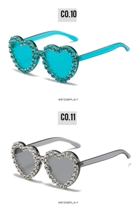 Détail des lunettes de soleil en forme de cœur avec strass scintillants en bleu et gris