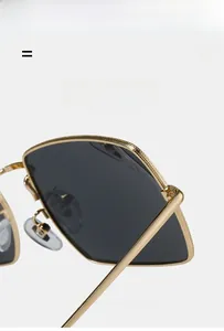 Detailed macro view of golden metal sunglass frame with knurled texture and clear nose pads