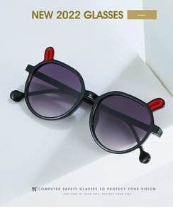 Detail of candy-colored kids sunglasses with cartoon rabbit ears on a white geometric stand