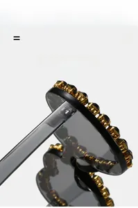 Détail macro de lunettes de soleil en forme de cœur avec strass noirs et base dorée