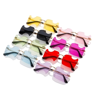 Lunettes de soleil sans monture avec verres ondulés et branches en métal doré colorées
