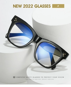Detail of square black frame glasses with blue light blocking lenses and gold rivets