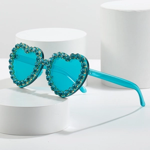 Lunettes de soleil cœur tendance avec verres bleu Tiffany et strass sur supports blancs