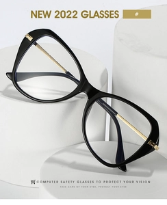 Detail of butterfly cat-eye glasses frame with gold accents on a white podium