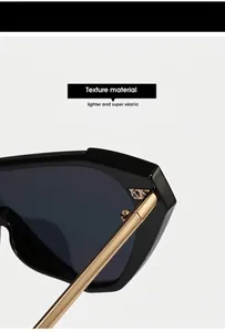 Detail view of stylish sunglasses showing black frame, gold hinge and textured material