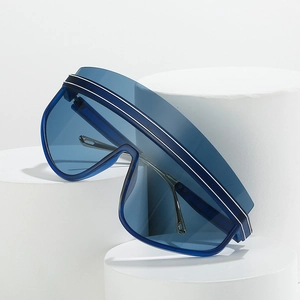 Oversized blue wrap-around sunglasses with white stripes on a minimalist geometric base
