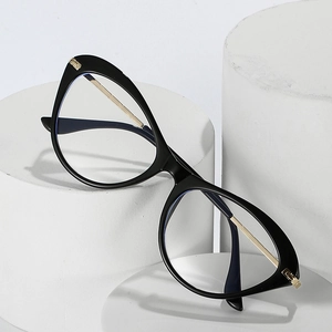 Chic black cat-eye glasses frame with gold metal temples on minimalist white pedestals