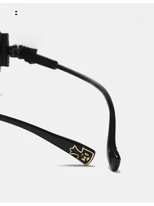 Macro detail of curved black glasses arm with golden cross emblem and arc design
