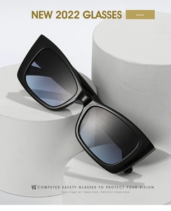 Detail of square black frame computer glasses with blue light coating on a white display