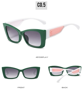 Detail view of cat eye sunglasses with green frame and white temples featuring pink accents