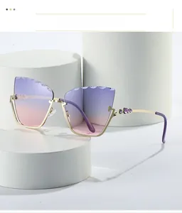 Close-up of cat eye sunglasses featuring purple gradient lenses and stone-set gold temples