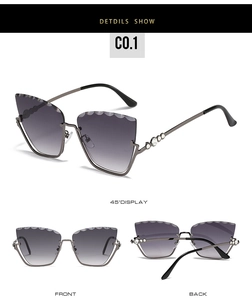 Detail view of cat eye sunglasses with wavy shell-cut gradient lenses and rhinestone accents