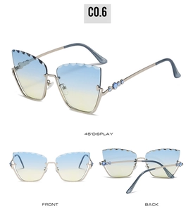 Detail view of cat eye sunglasses with gradient lenses and blue rhinestones on gold frame