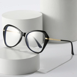 Chic black cat-eye anti-blue light glasses with gold metal temples on minimalist stand